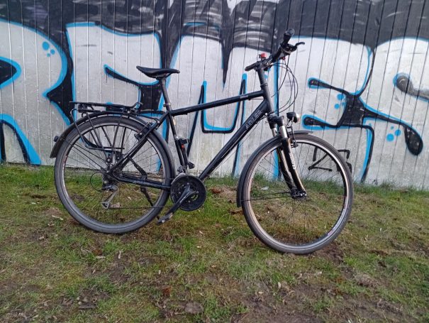 Adler Treckingrad mit custom wheels by goetherad Schwarzes Fahrrad vor einer Graffiti-Wand mit bunten Buchstaben.